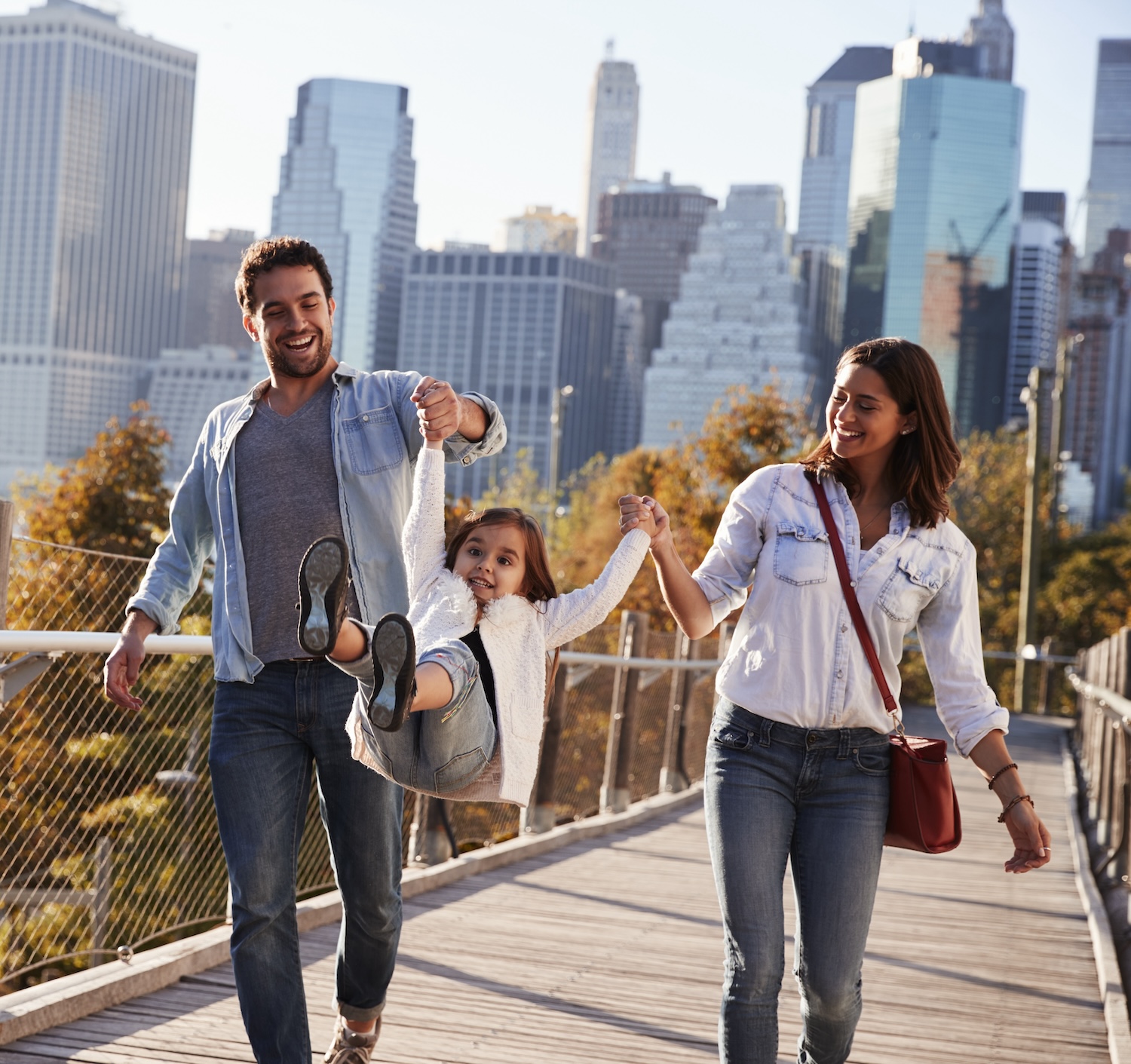 Young family with daughter taking a walk on footbridge